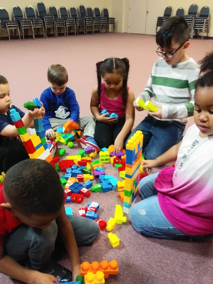 Children playing with colorful building blocks on the floor
