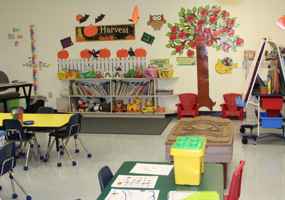 Classroom decorated with a harvest theme, including pumpkins and an apple tree