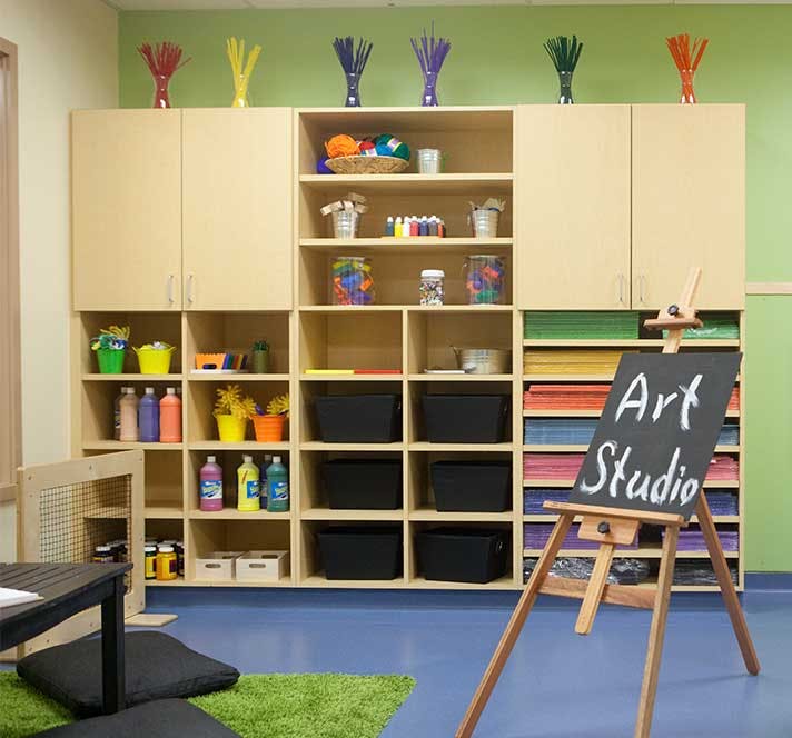 Art studio with shelves of supplies and an easel with "Art Studio" written on it