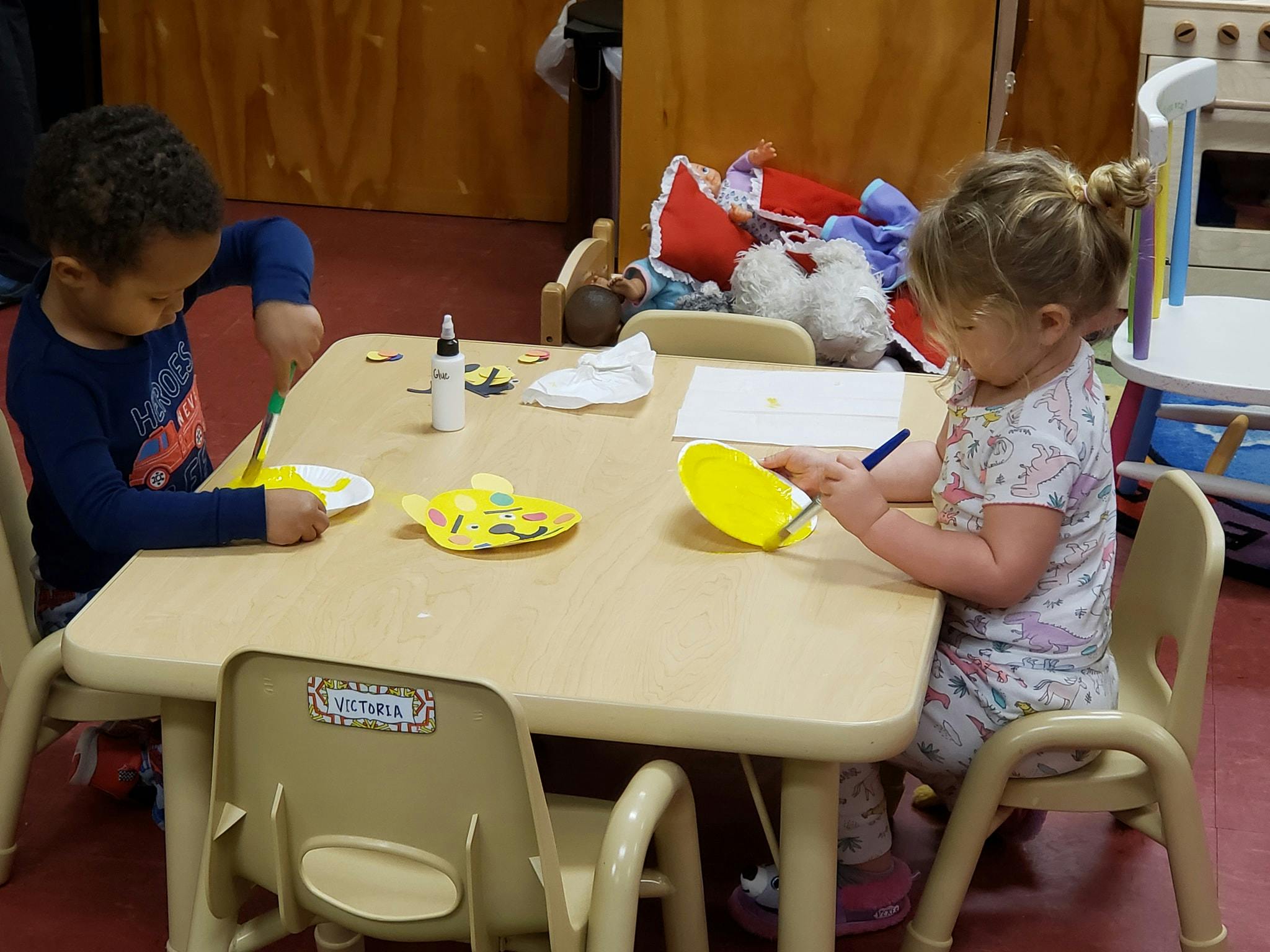 Two children at a table doing crafts