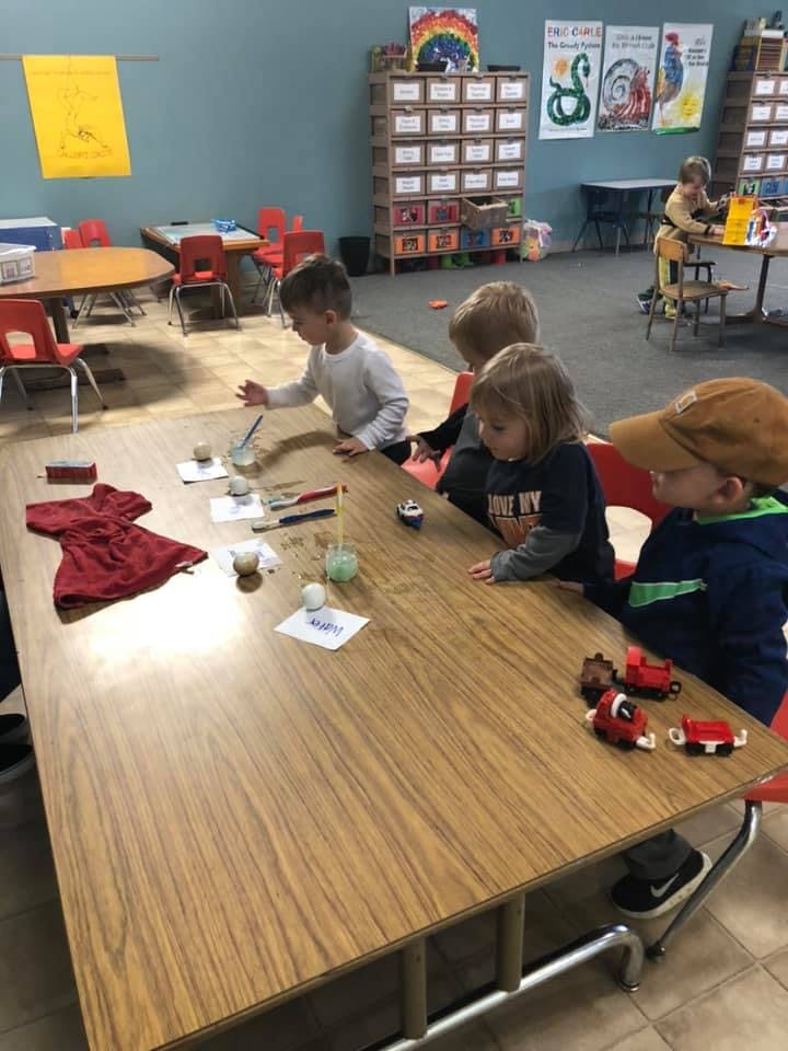 Children at a table with various items