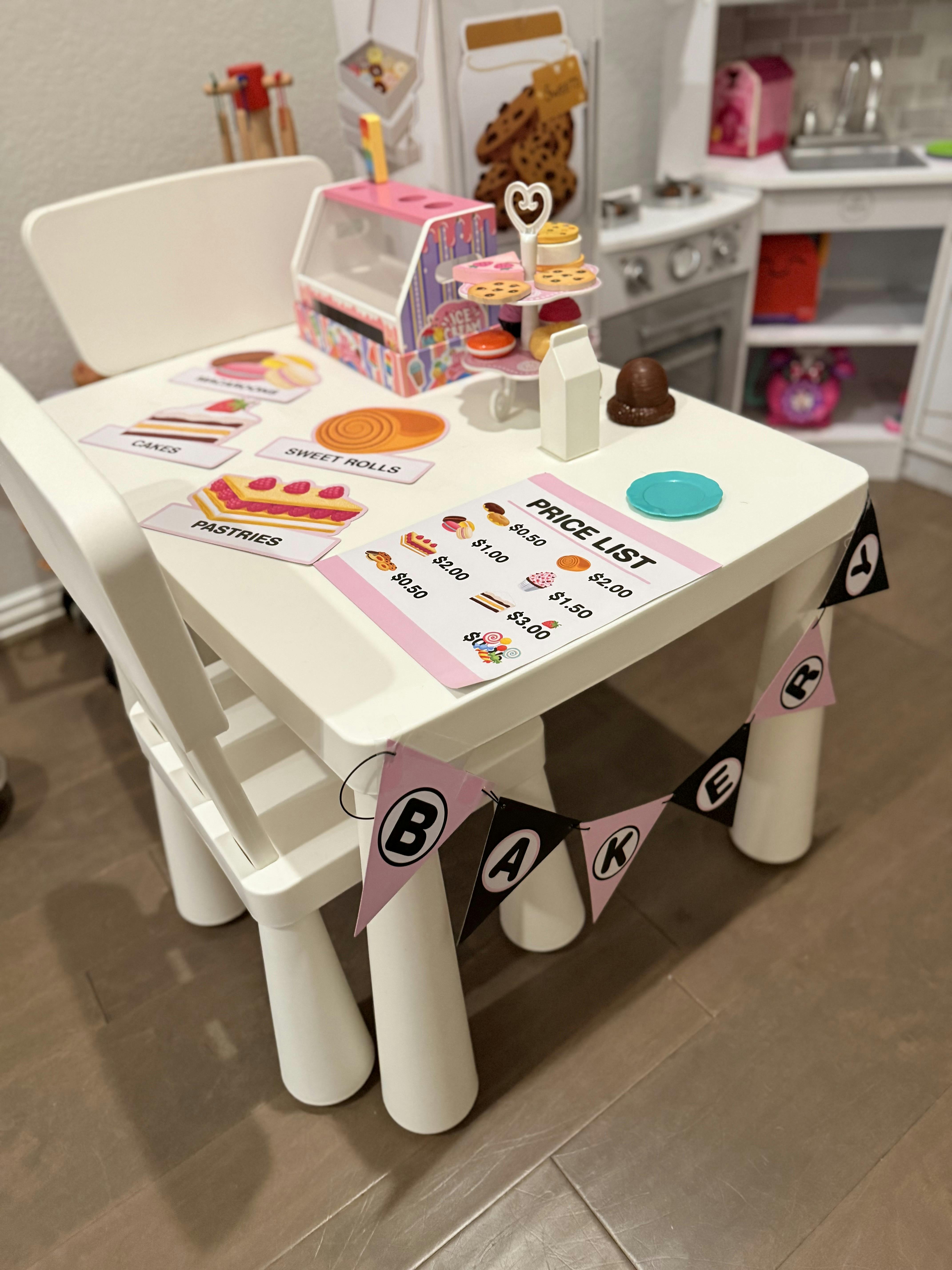 Play kitchen table with toy pastries and a price list