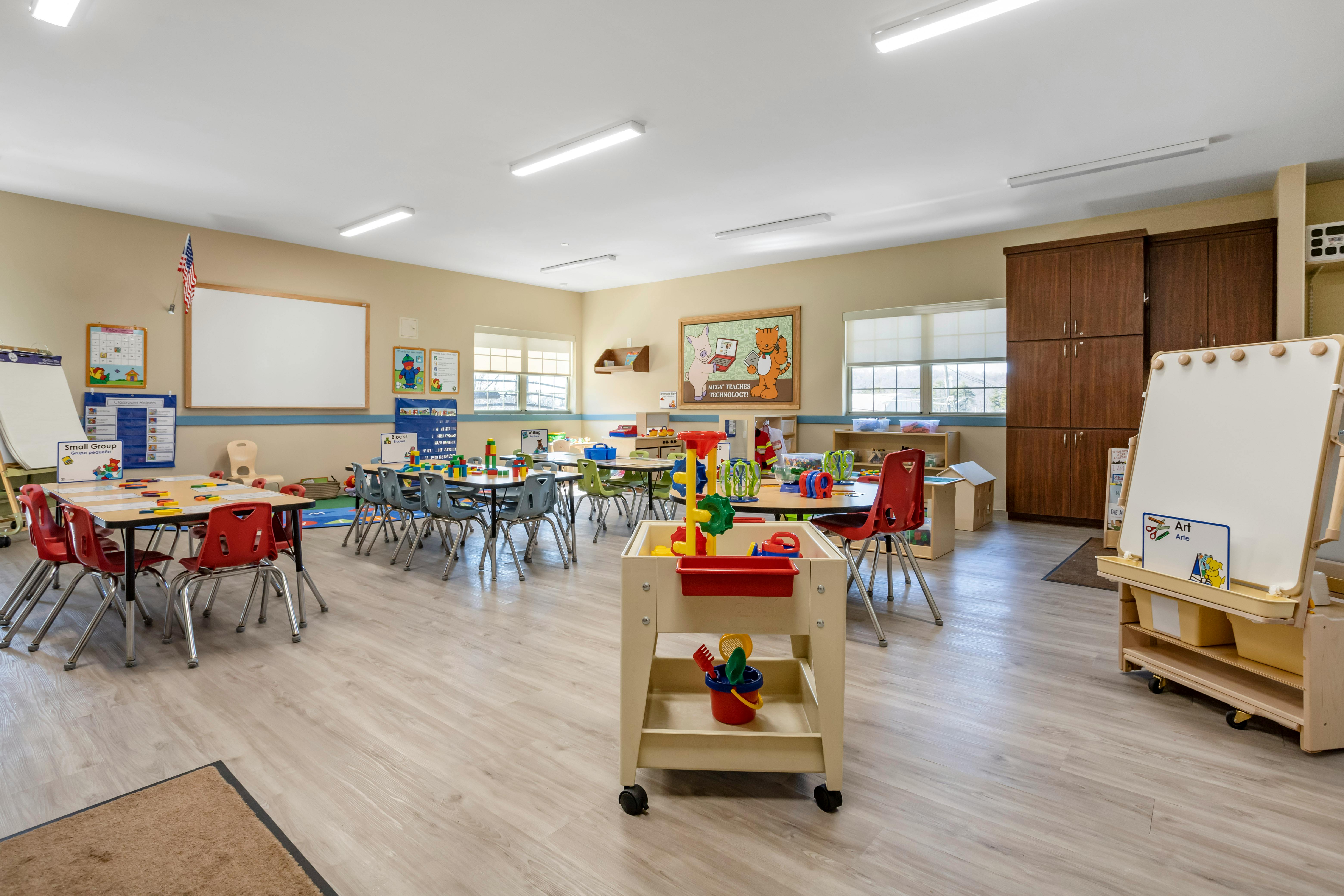 Classroom with multiple small tables, chairs, and learning materials