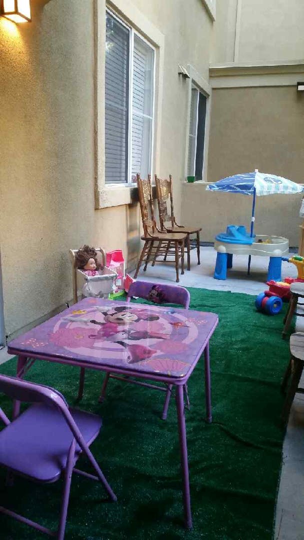 Patio with children's table and chairs, doll in high chair, and water table