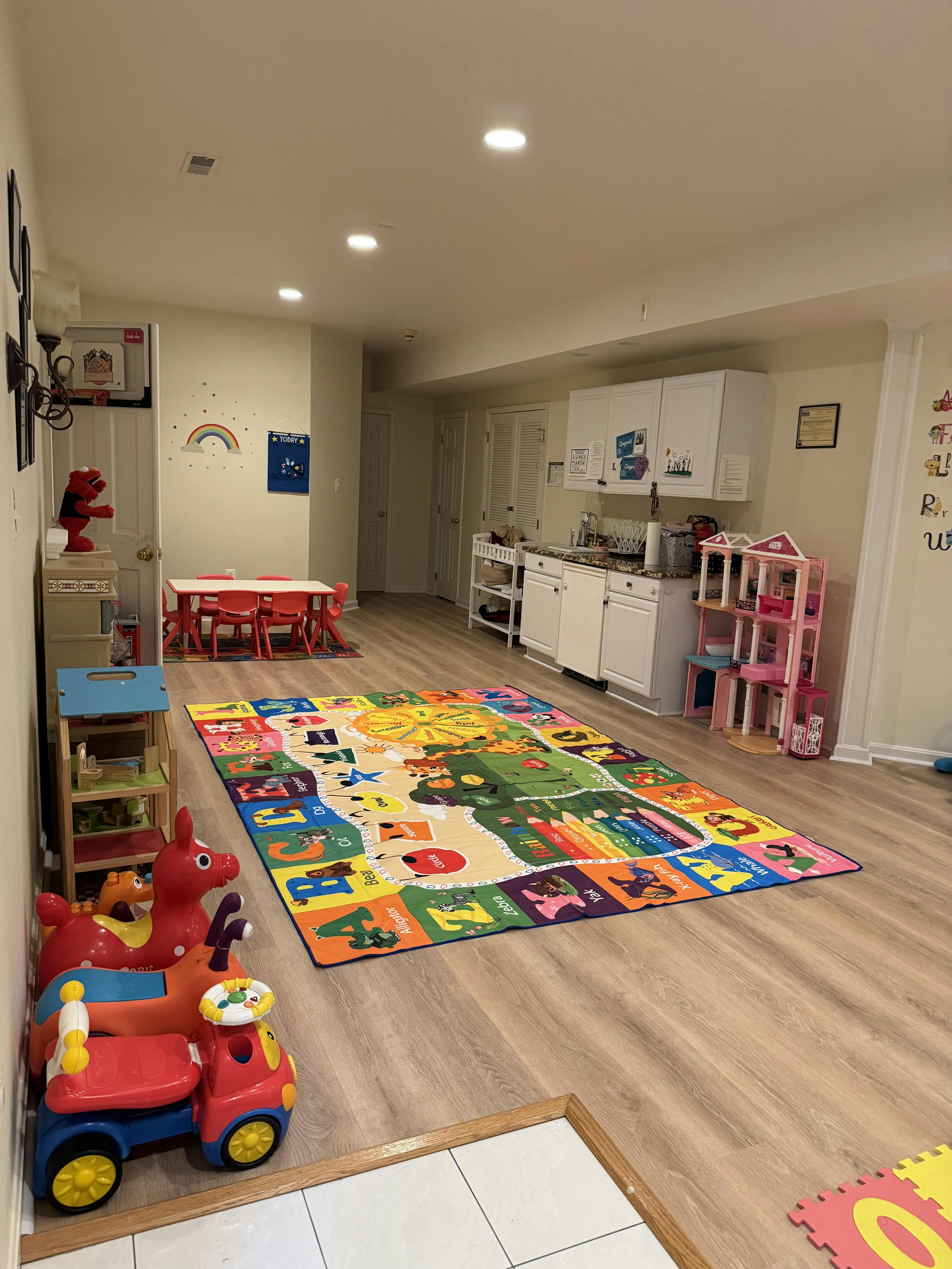 Playroom with colorful rug, small table and chairs, and toy kitchen