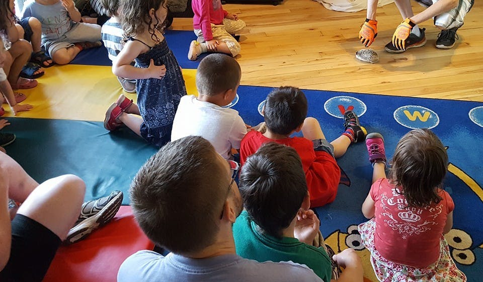 Children sitting on a colorful mat in a classroom
