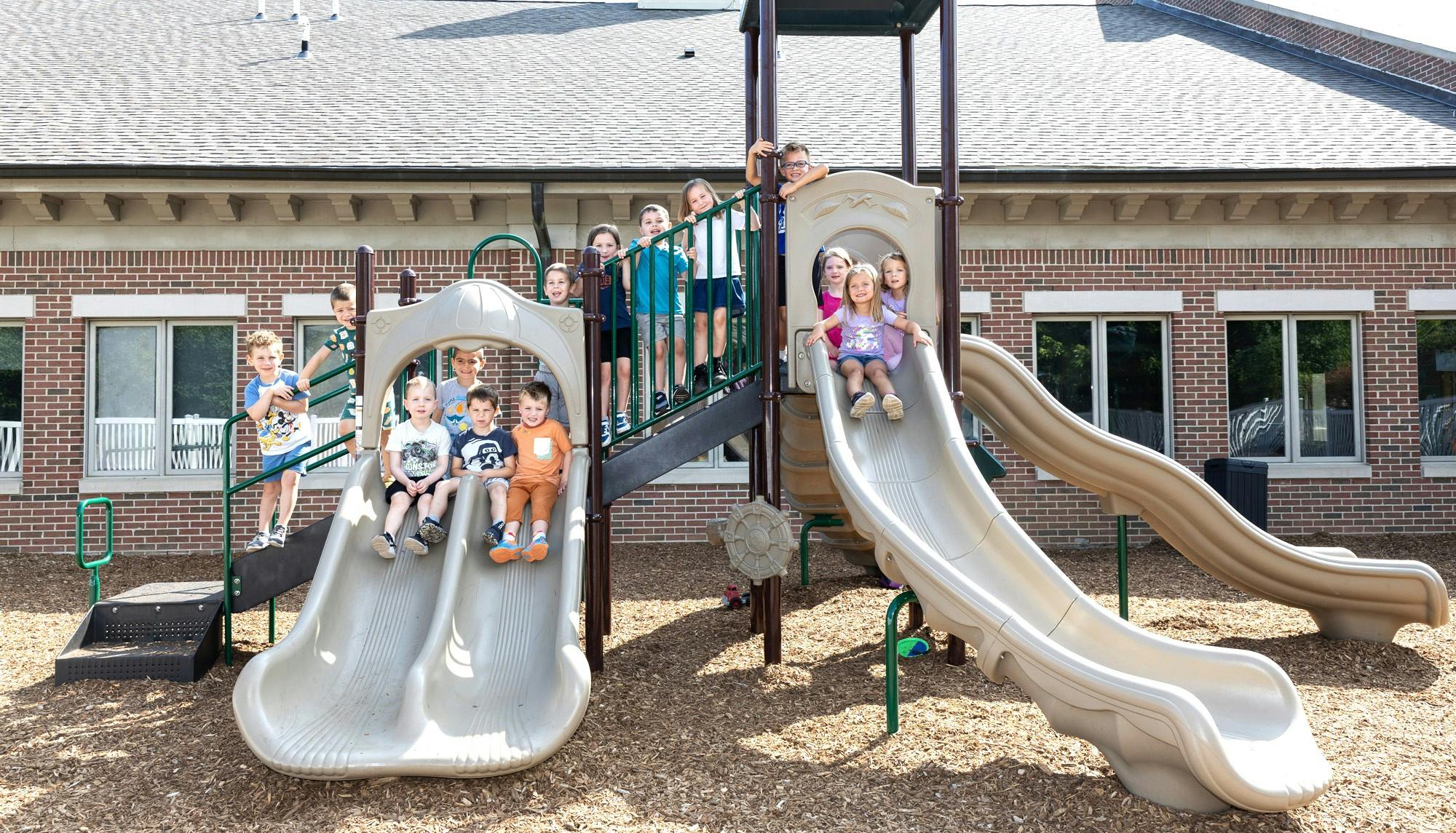 Group of children standing and sitting on a playground structure
