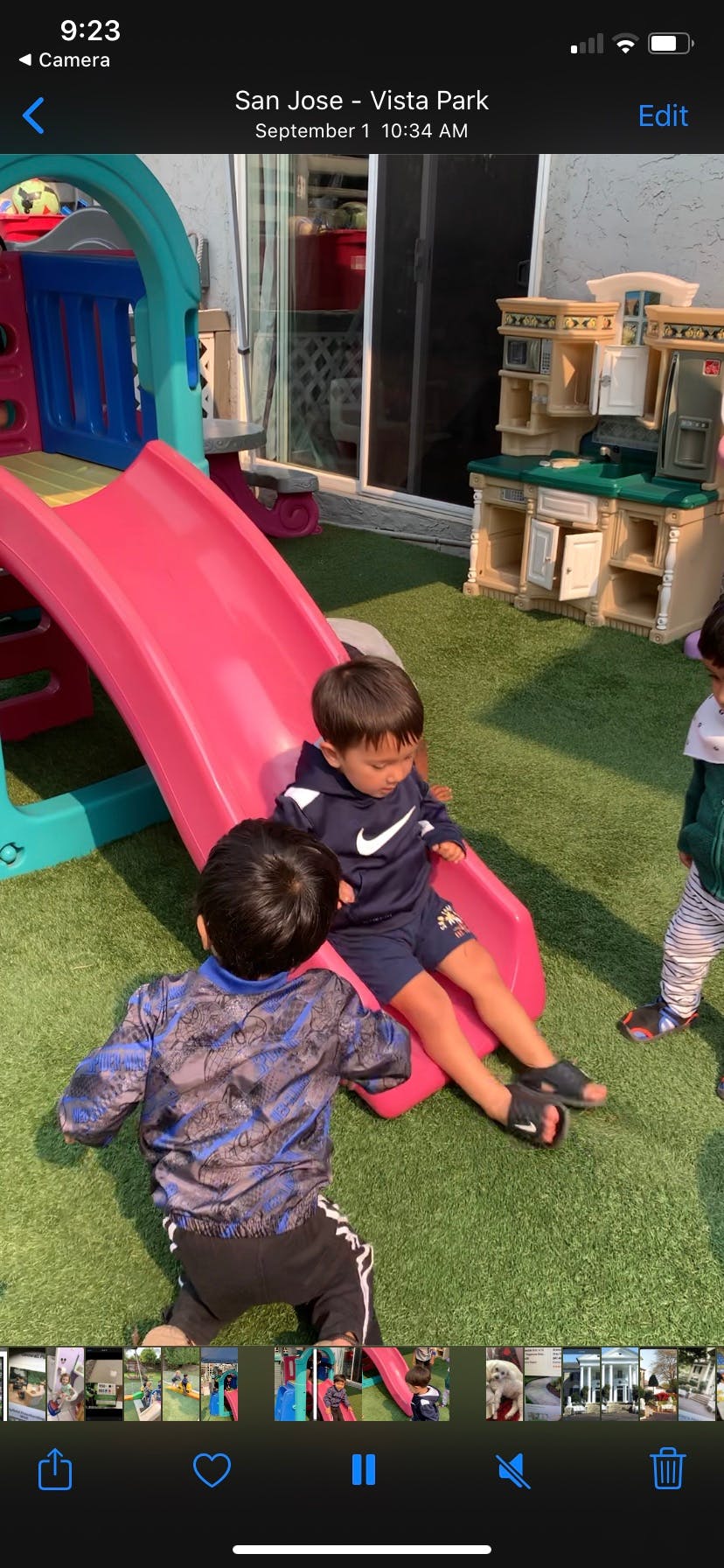 Two children playing on a pink slide on a playground