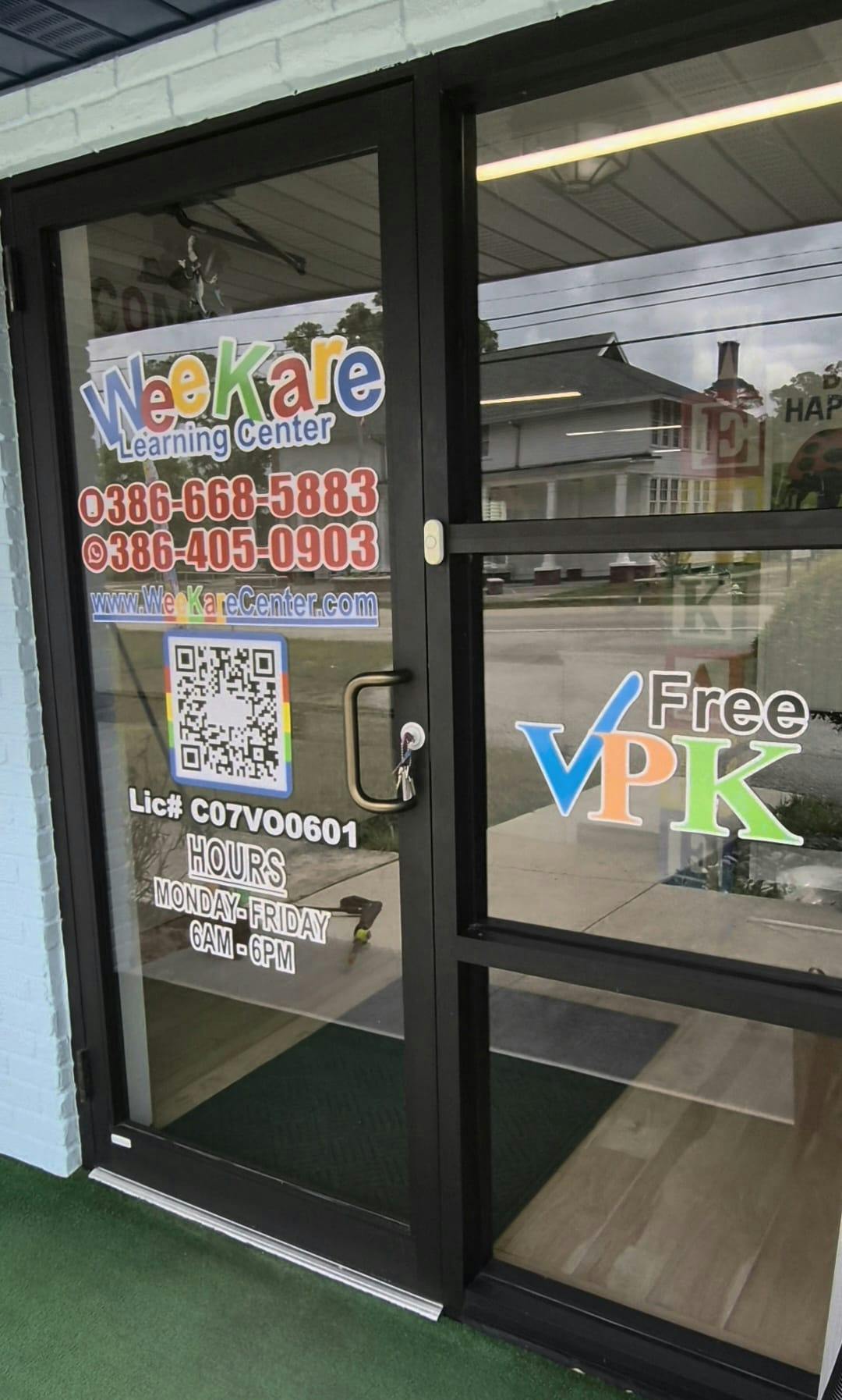 WeeKare Learning Center sign on a glass door with contact information and hours