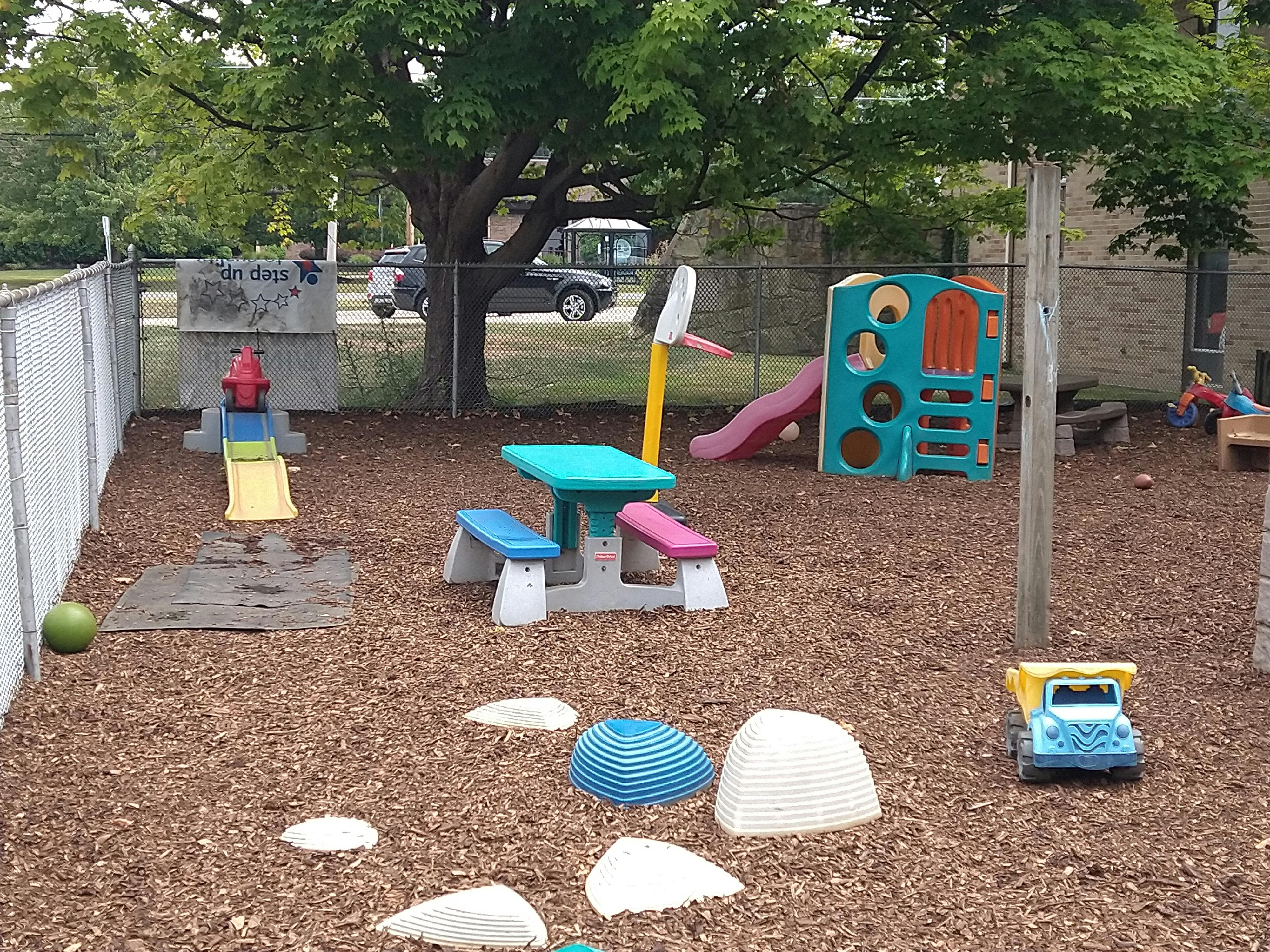 Outdoor playground with slides, play structure, and picnic table