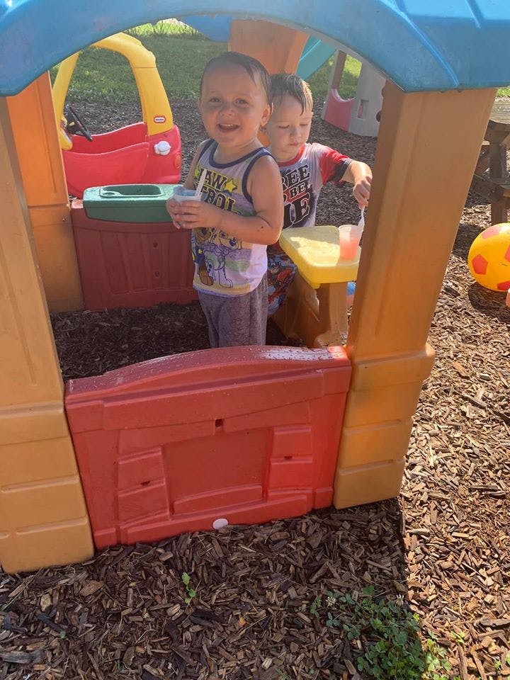Two children playing in a plastic playhouse