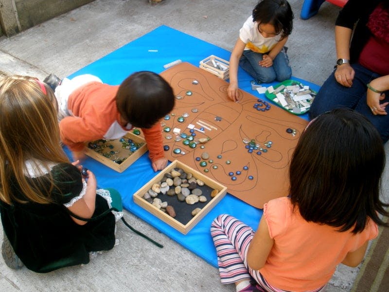 Children playing with small objects on a mat