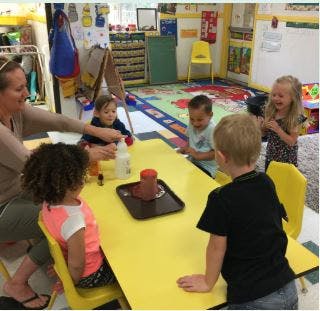 Adult and children at a table in a classroom