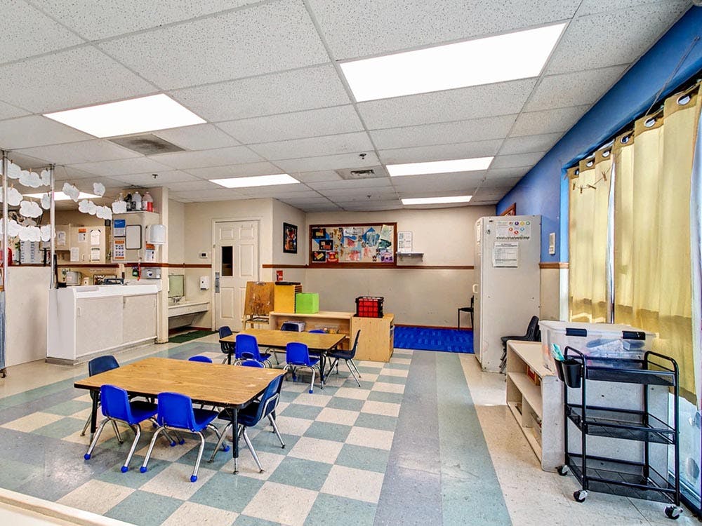 Classroom with small tables and chairs, and a checkered floor