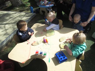 Three children at a table with art supplies