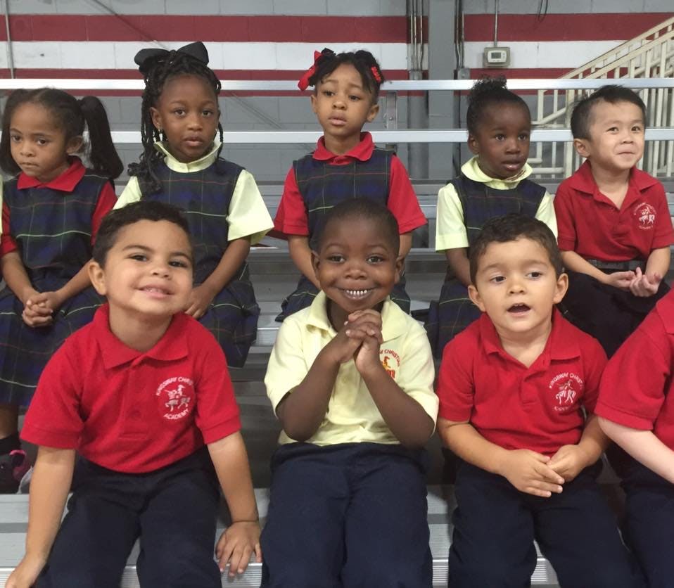 Group of children in school uniforms sitting on bleachers