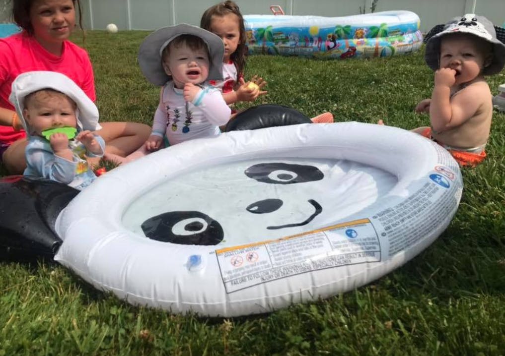 Children sitting around an inflatable panda pool