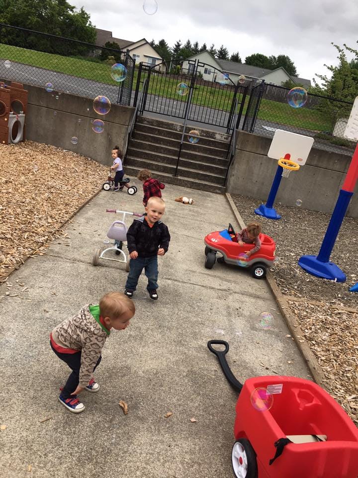 Children playing outdoors with bubbles and toys