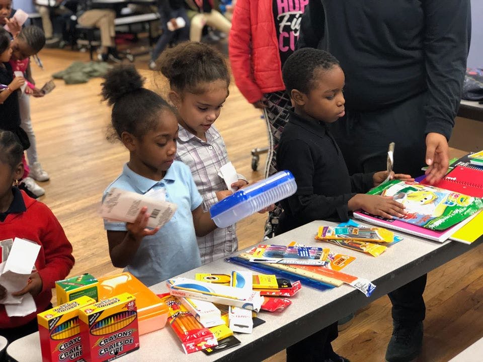 Children looking at school supplies on a table