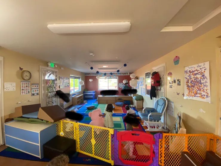 Playroom with colorful mats, toys, and safety gates