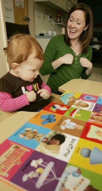 Adult and child looking at a colorful board book