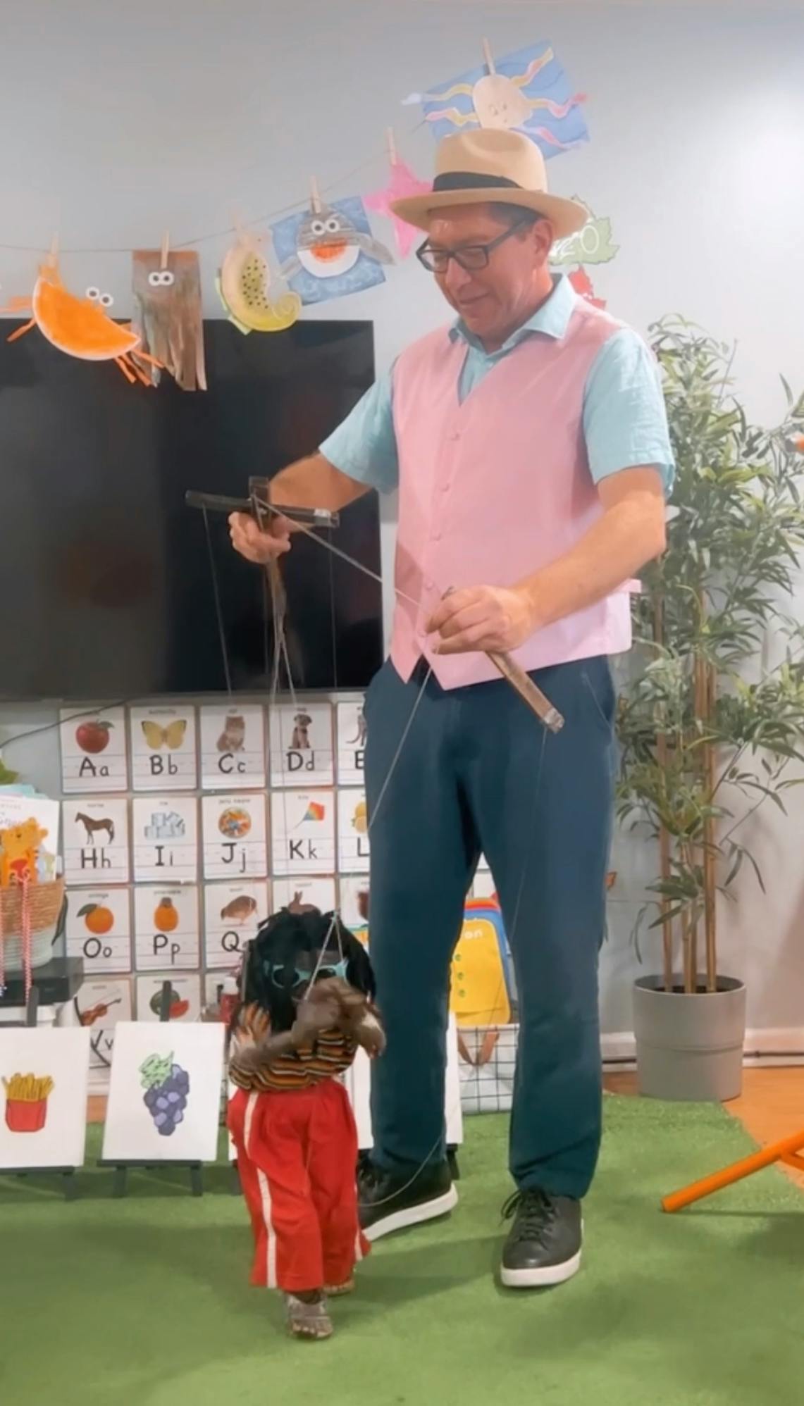 Person in a hat operating a puppet