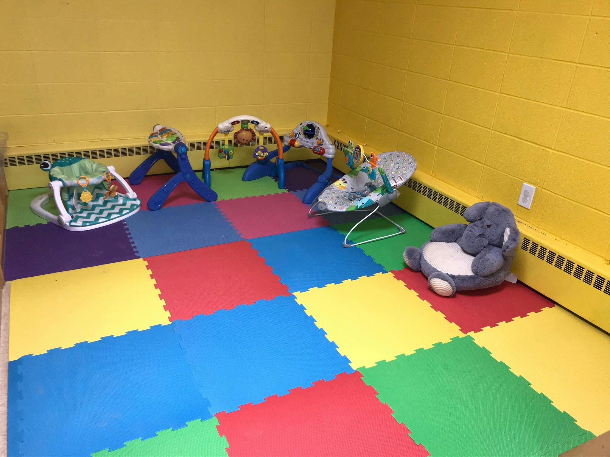 Playroom with colorful interlocking floor mats and baby activity centers