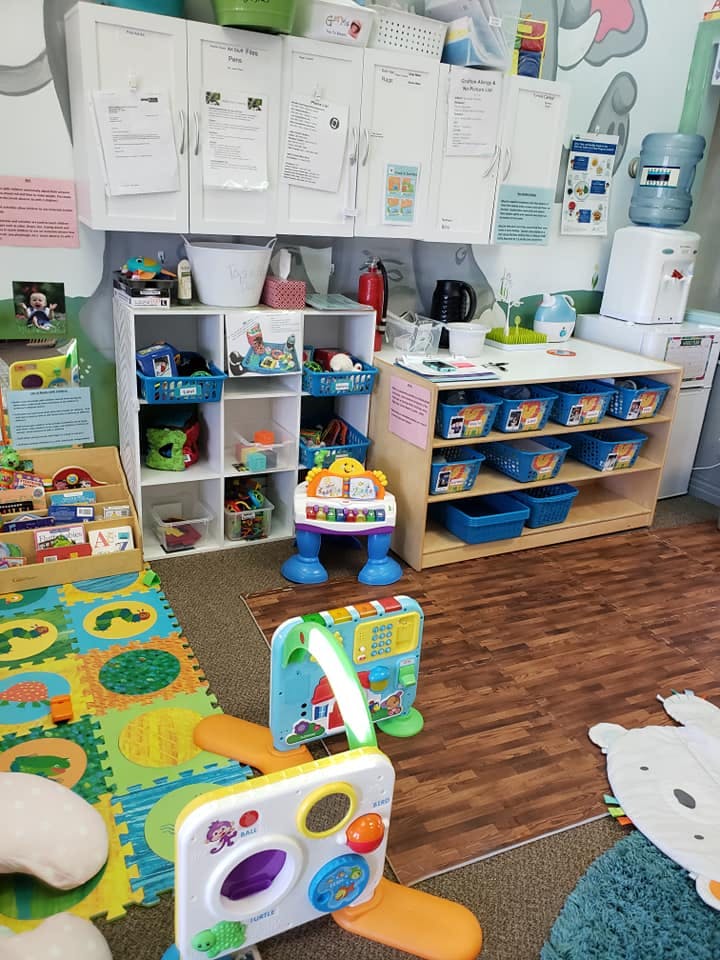 Playroom with toys, shelves, and a colorful floor mat