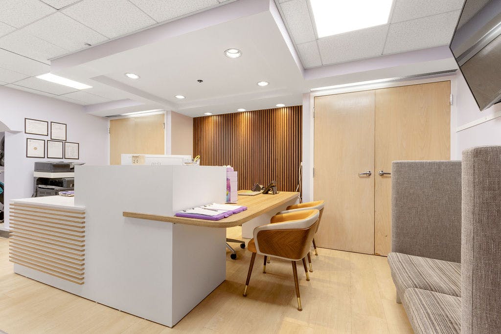 Reception desk with chairs and a wooden accent wall