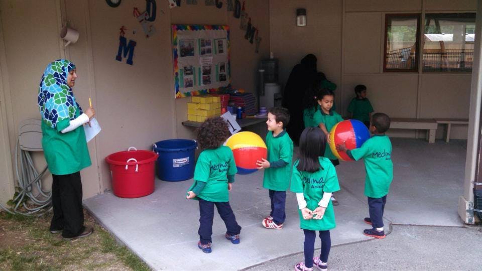 Adult and children playing with beach balls