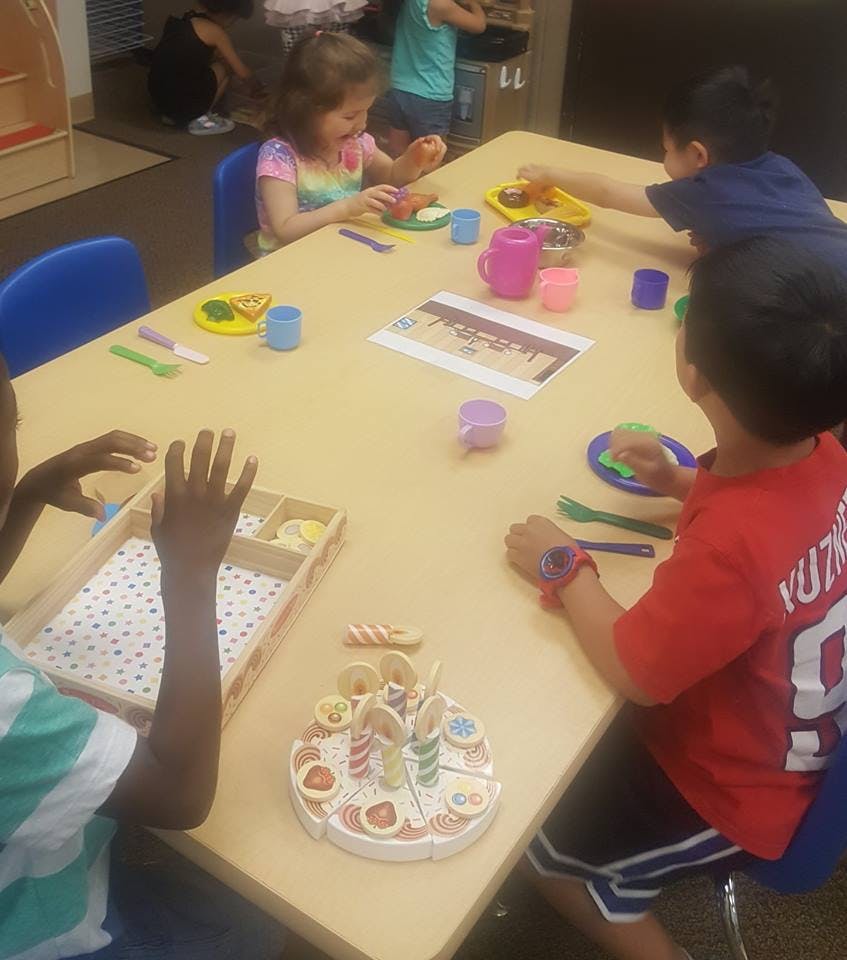 Children playing with toy food at a table