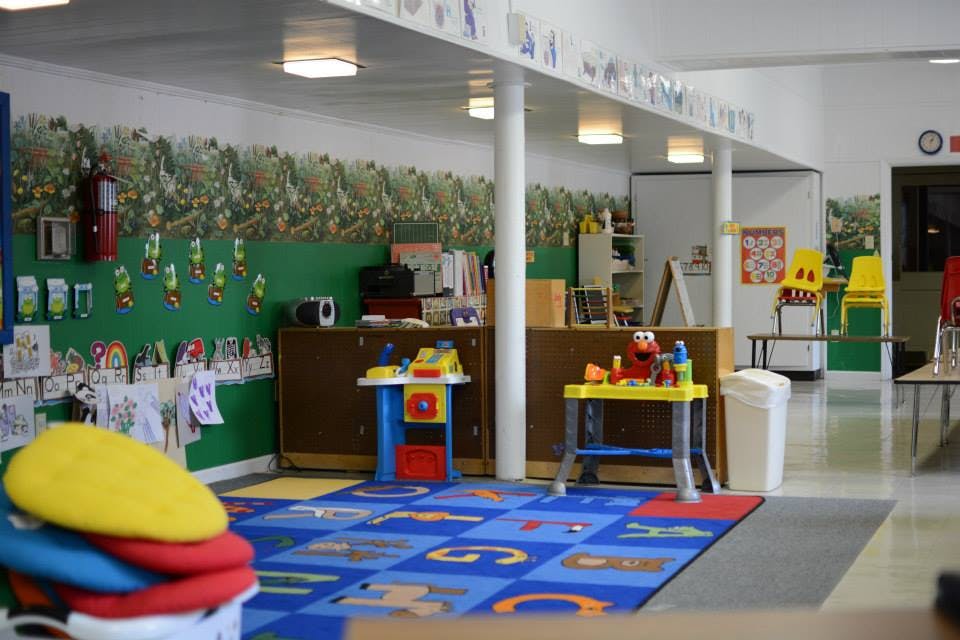 Classroom with alphabet rug and play tables