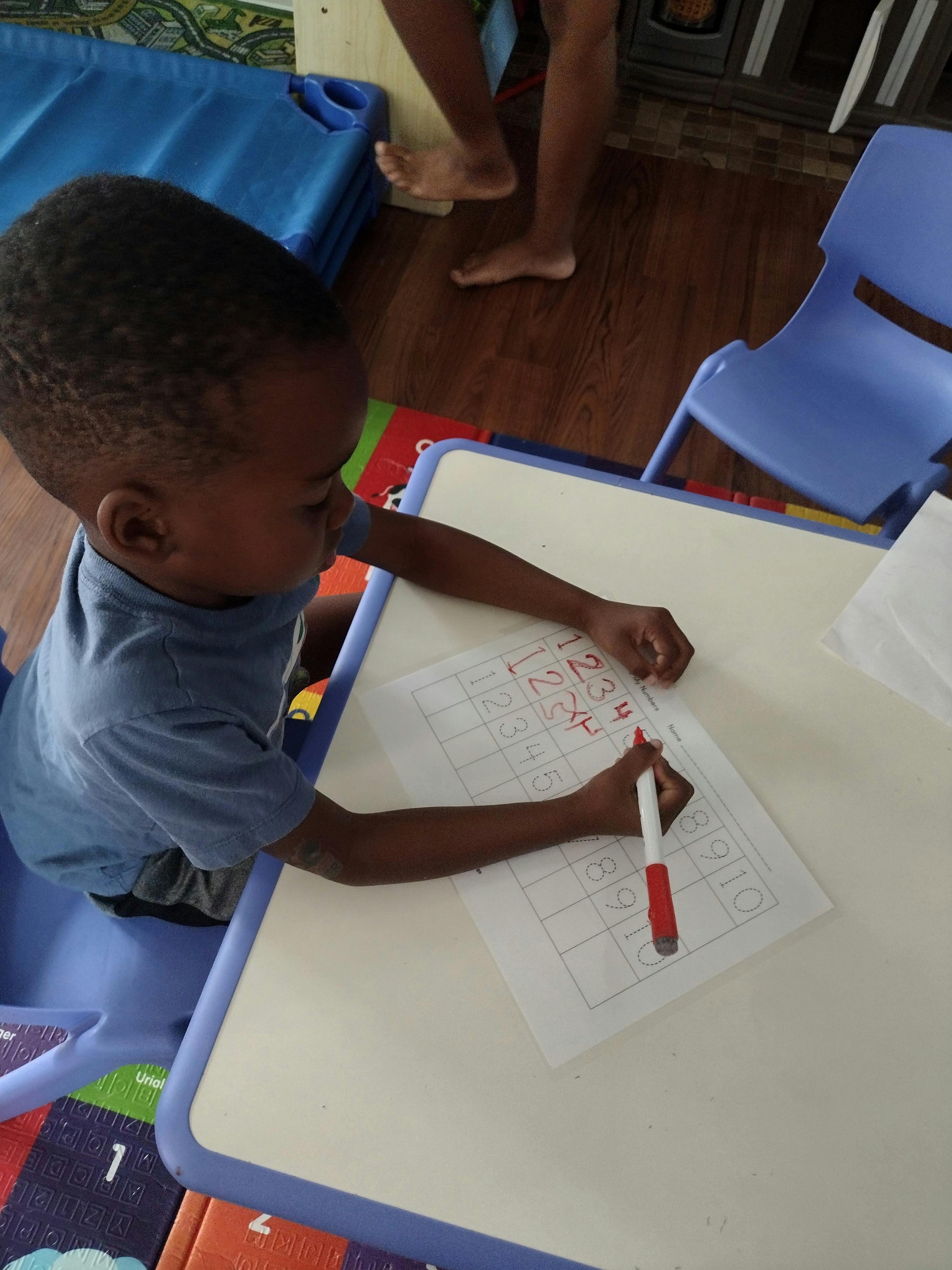 Child writing on paper at a table