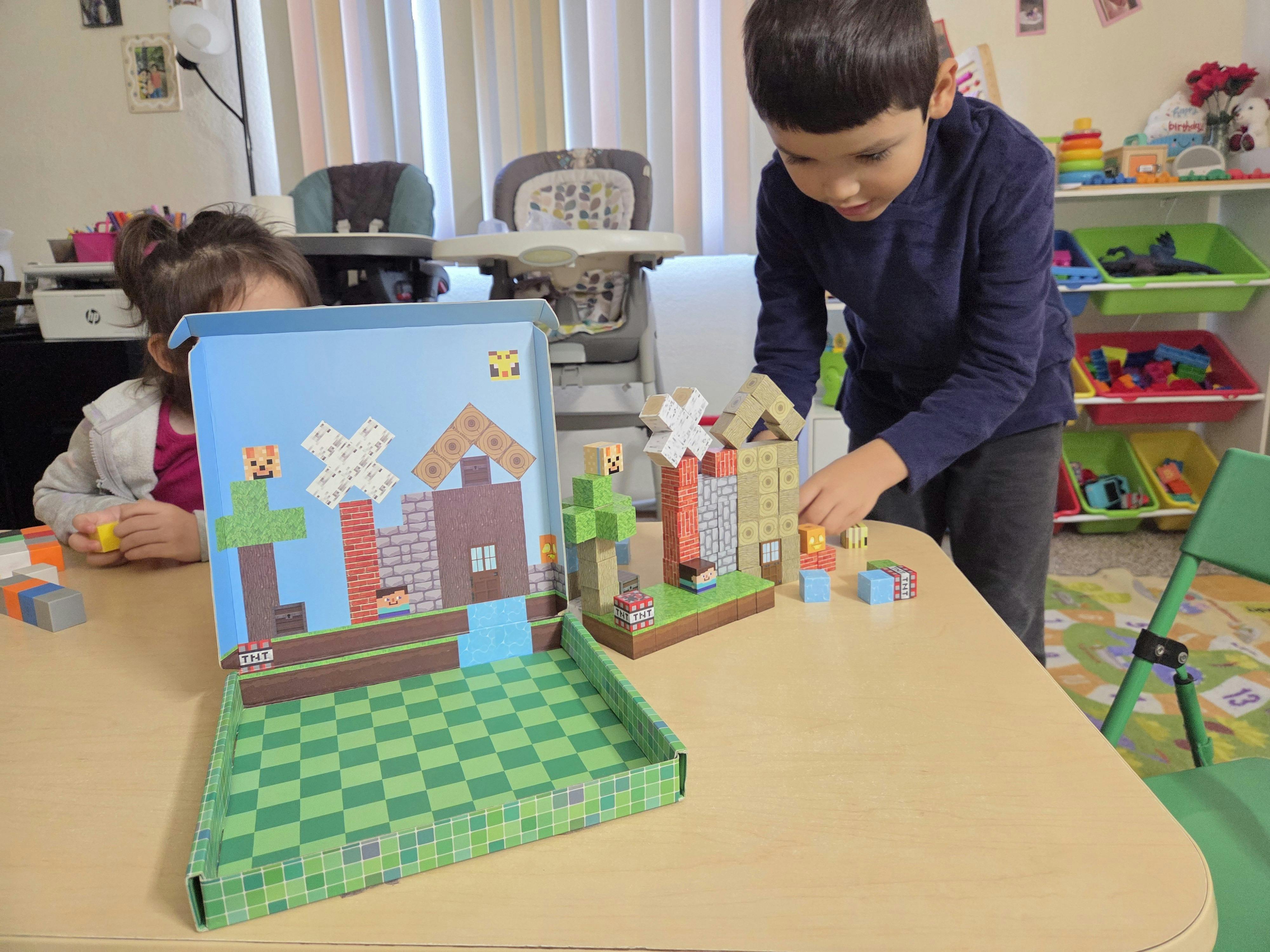Two children playing with building blocks on a table