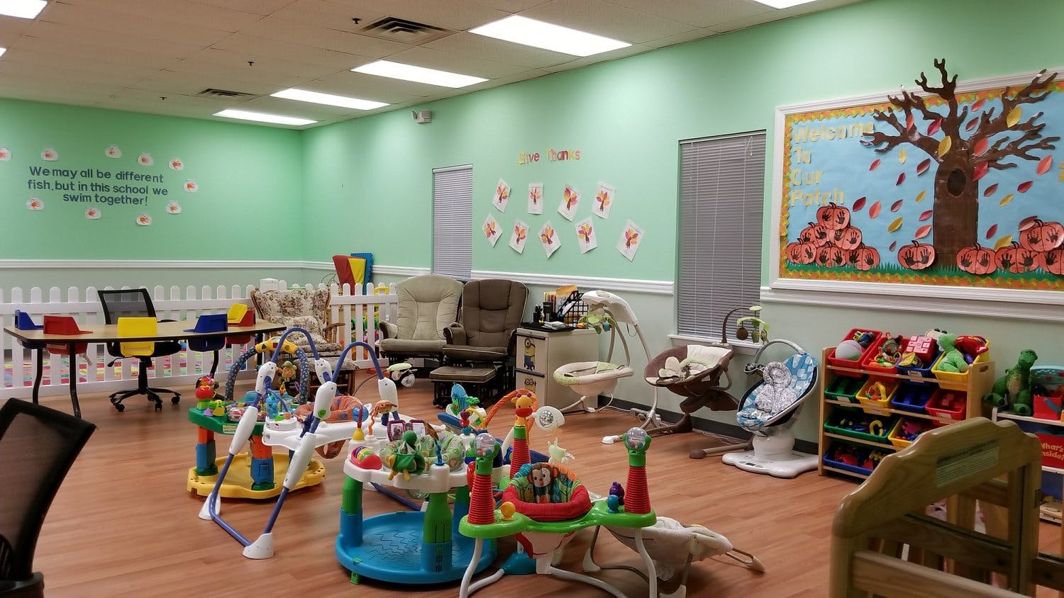 Playroom with various baby and child toys, chairs, and a table