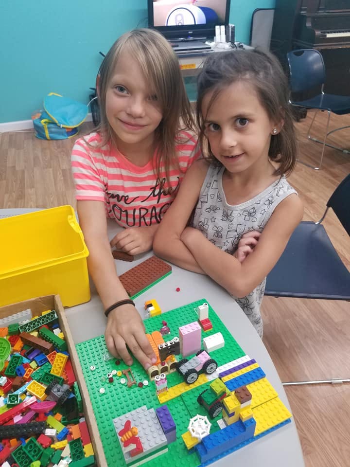 Two children playing with colorful building blocks on a table
