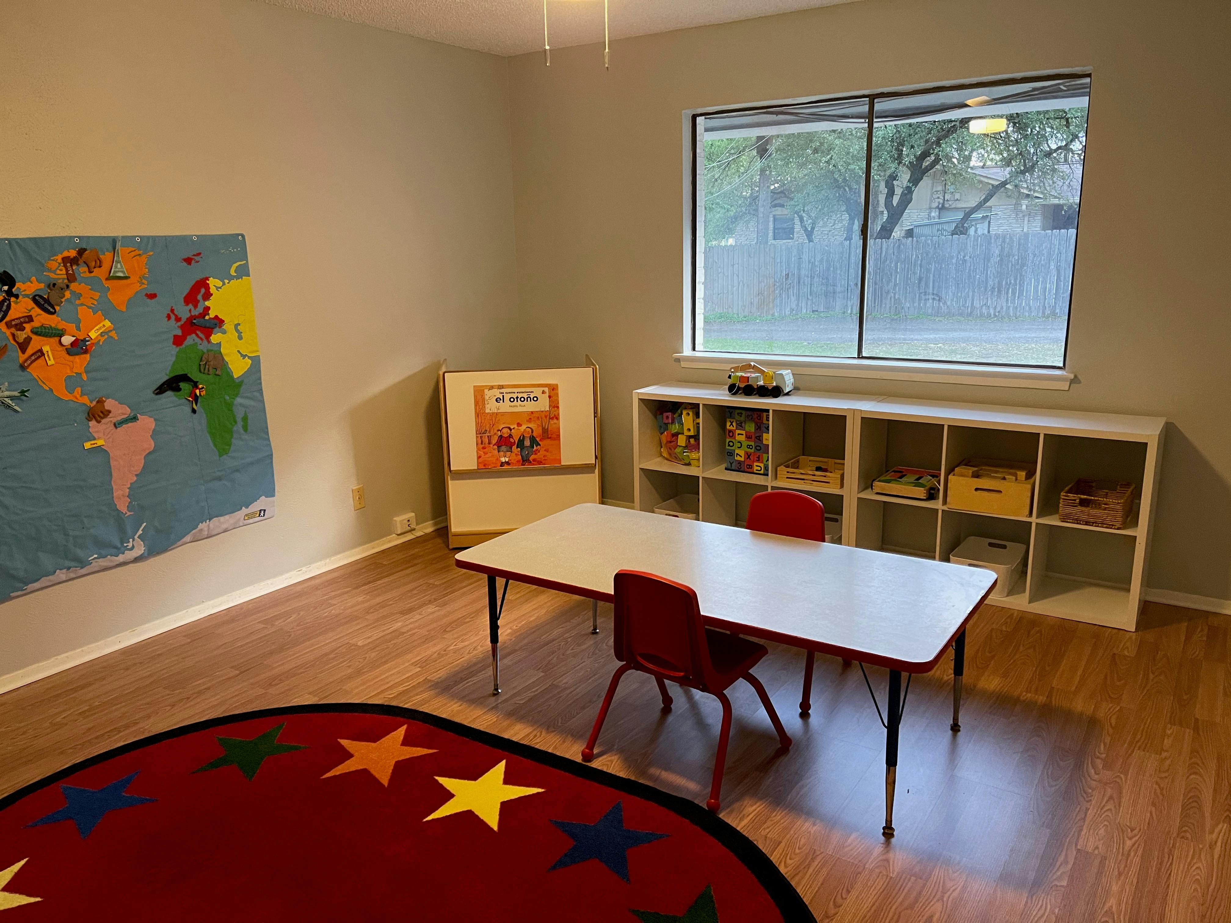 Classroom with a world map, table, chairs, and storage shelves