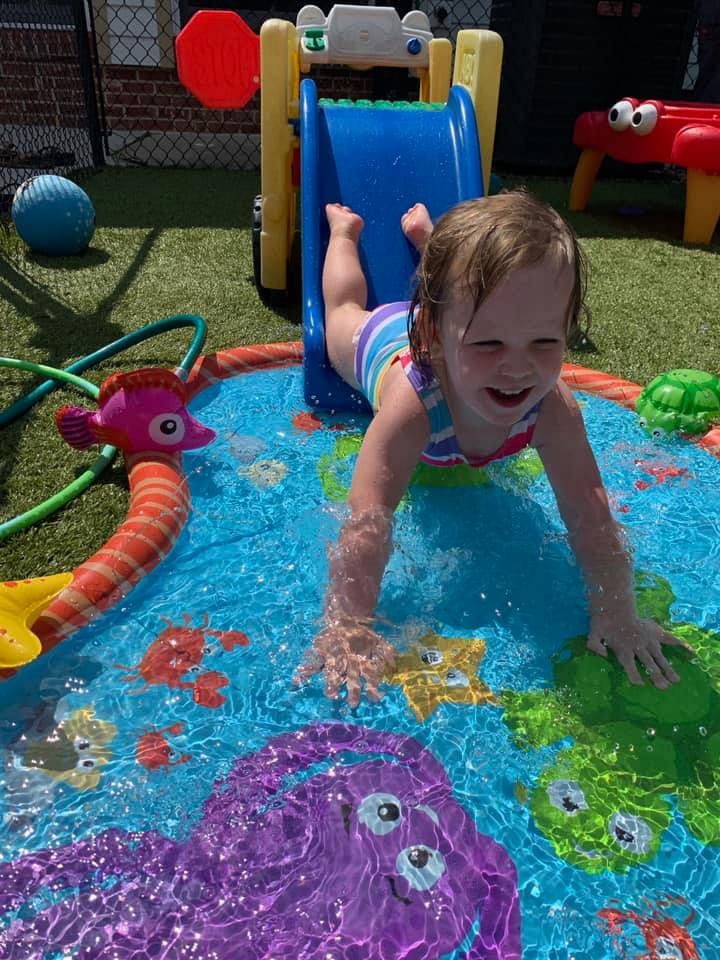 Child sliding into a splash pad