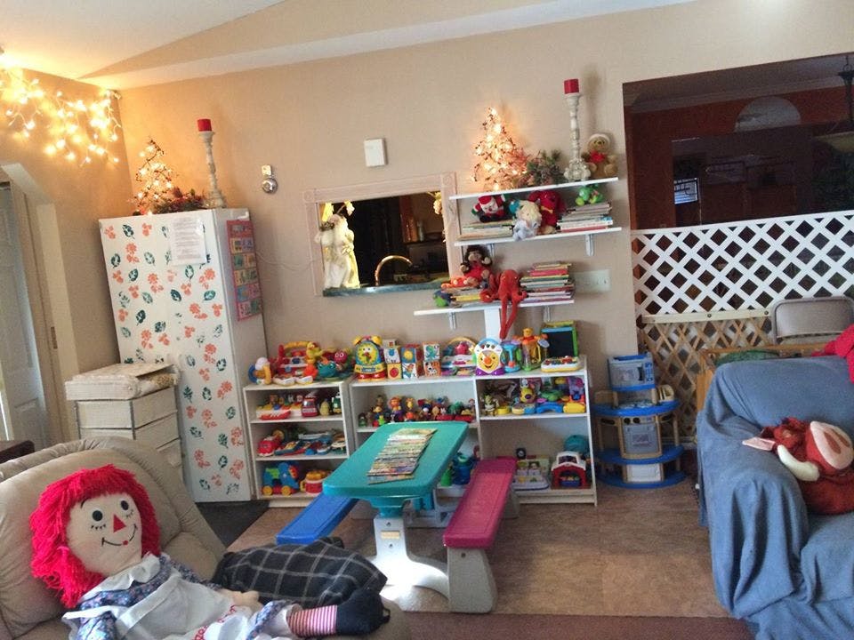 Living room with shelves of toys and a doll on a chair