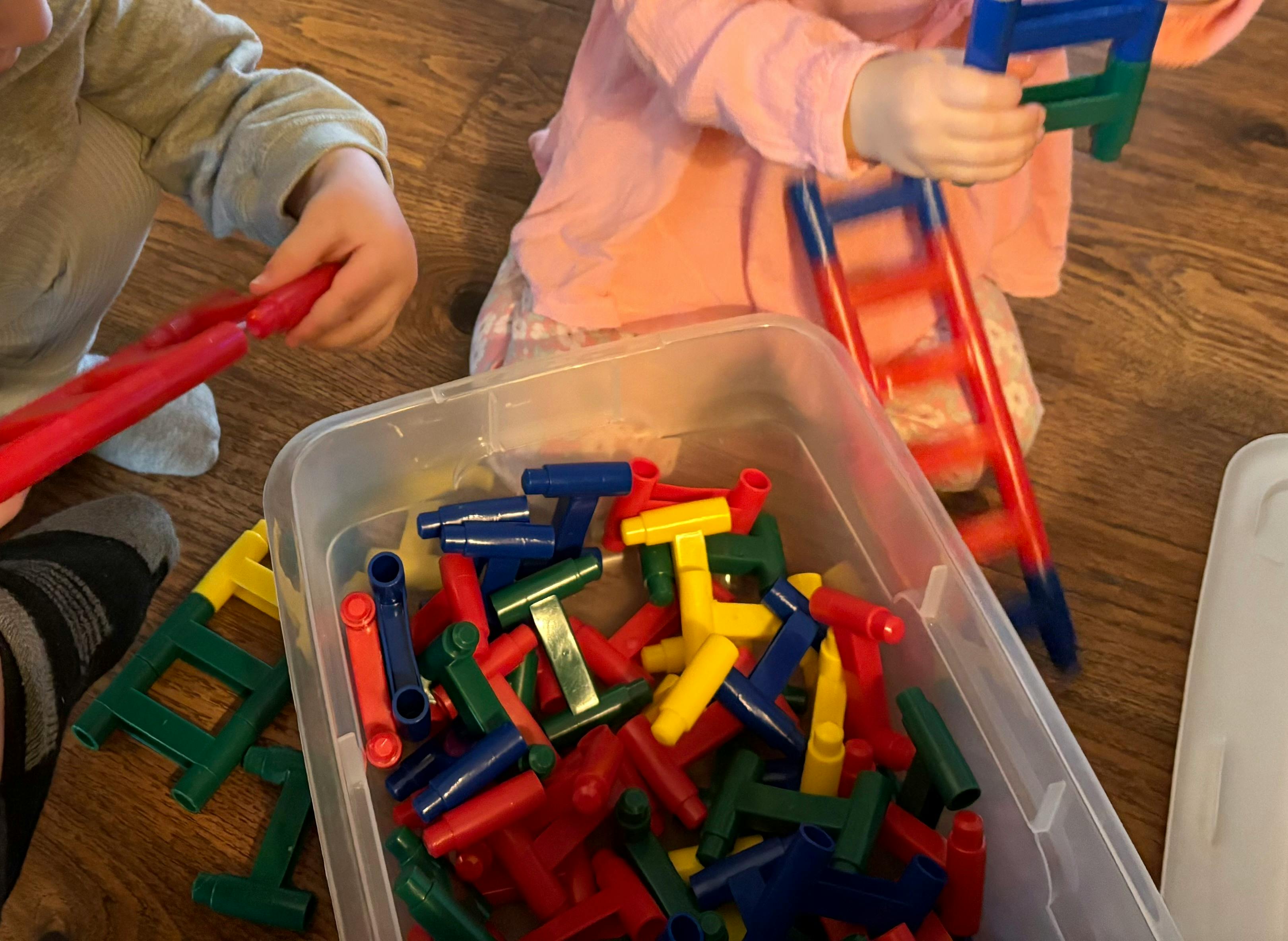 Two children playing with colorful building toys