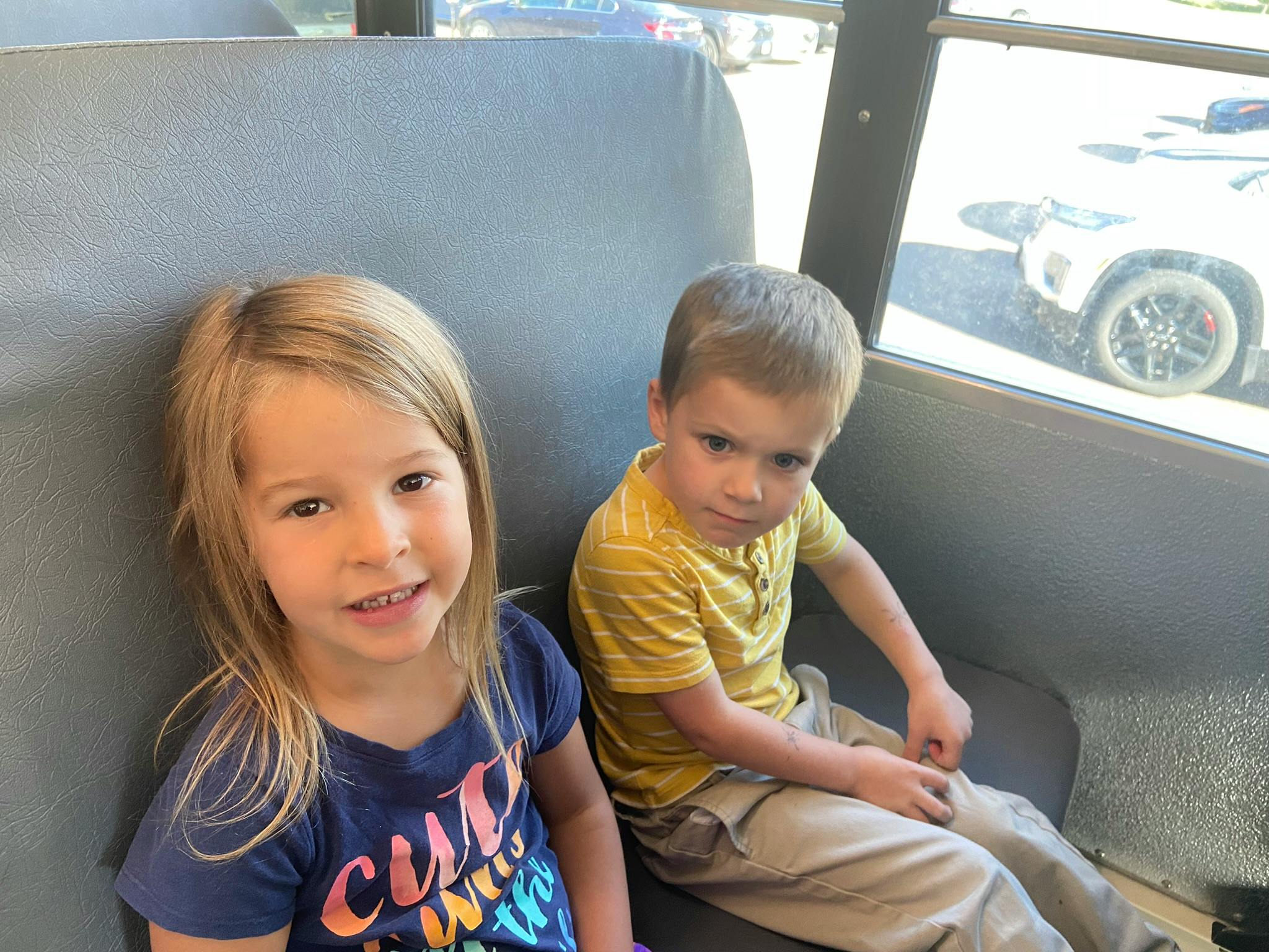 Two children sitting on a bus seat
