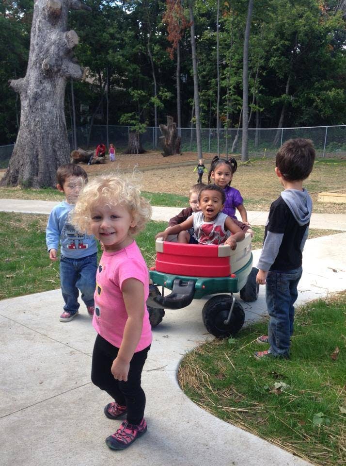 Children playing outdoors with a wagon