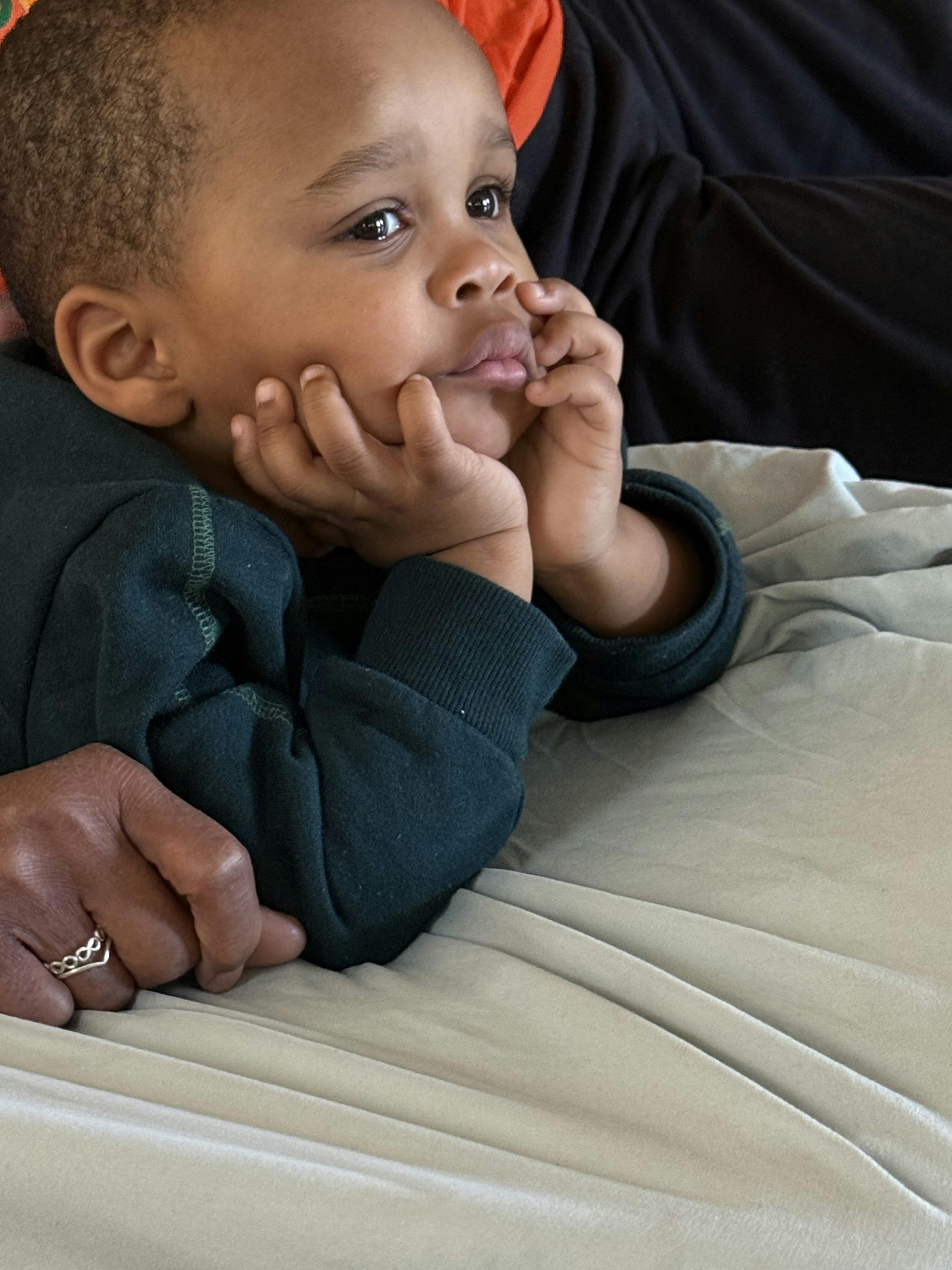 Child resting chin on hands, looking to the side