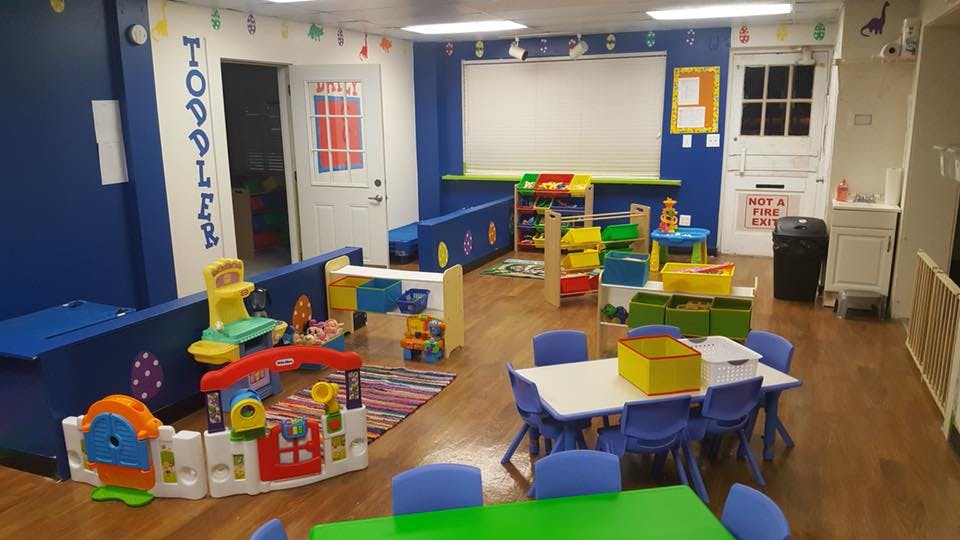 Toddler classroom with play area and small tables
