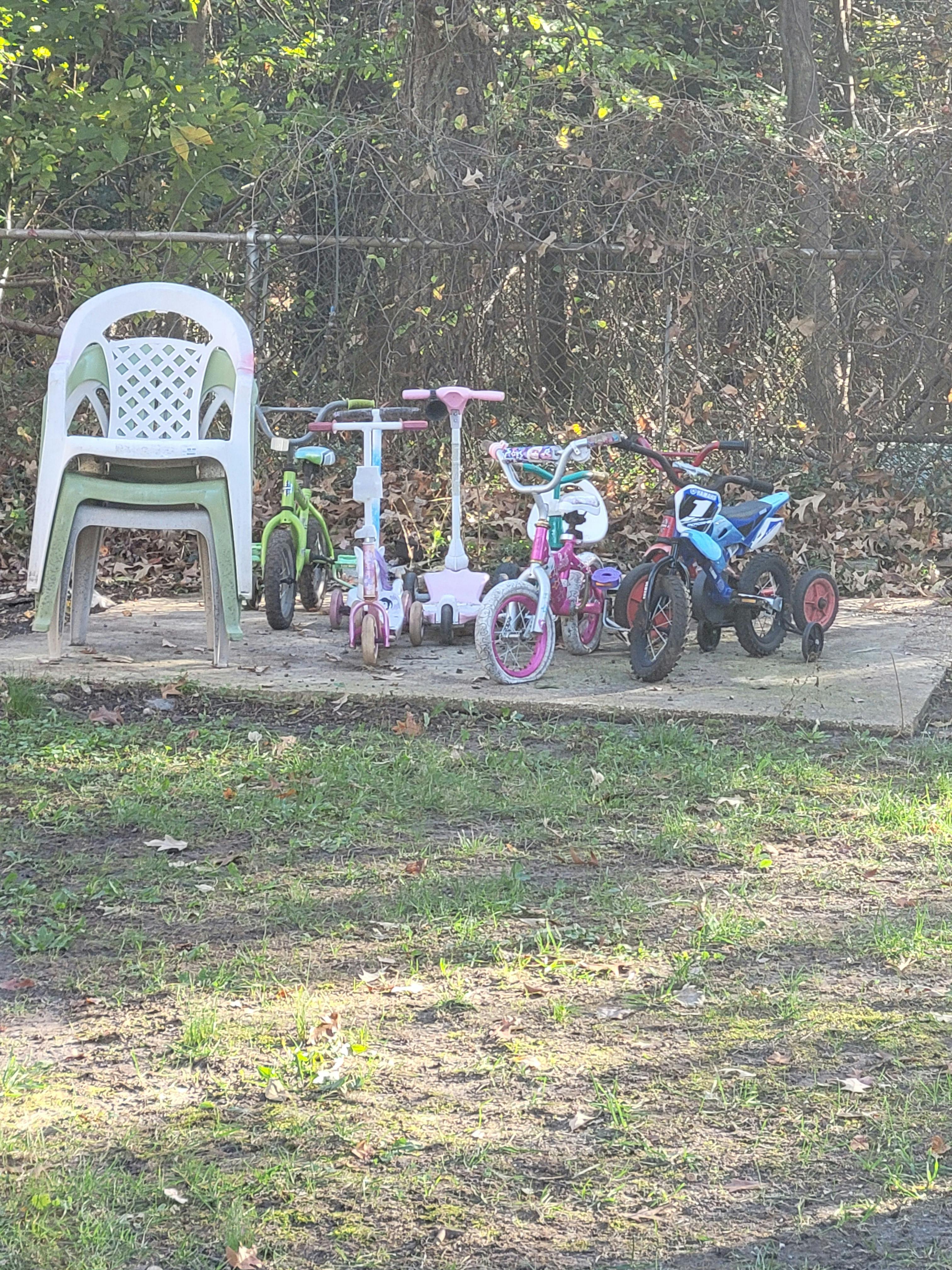 Stack of chairs and several children's bikes and scooters