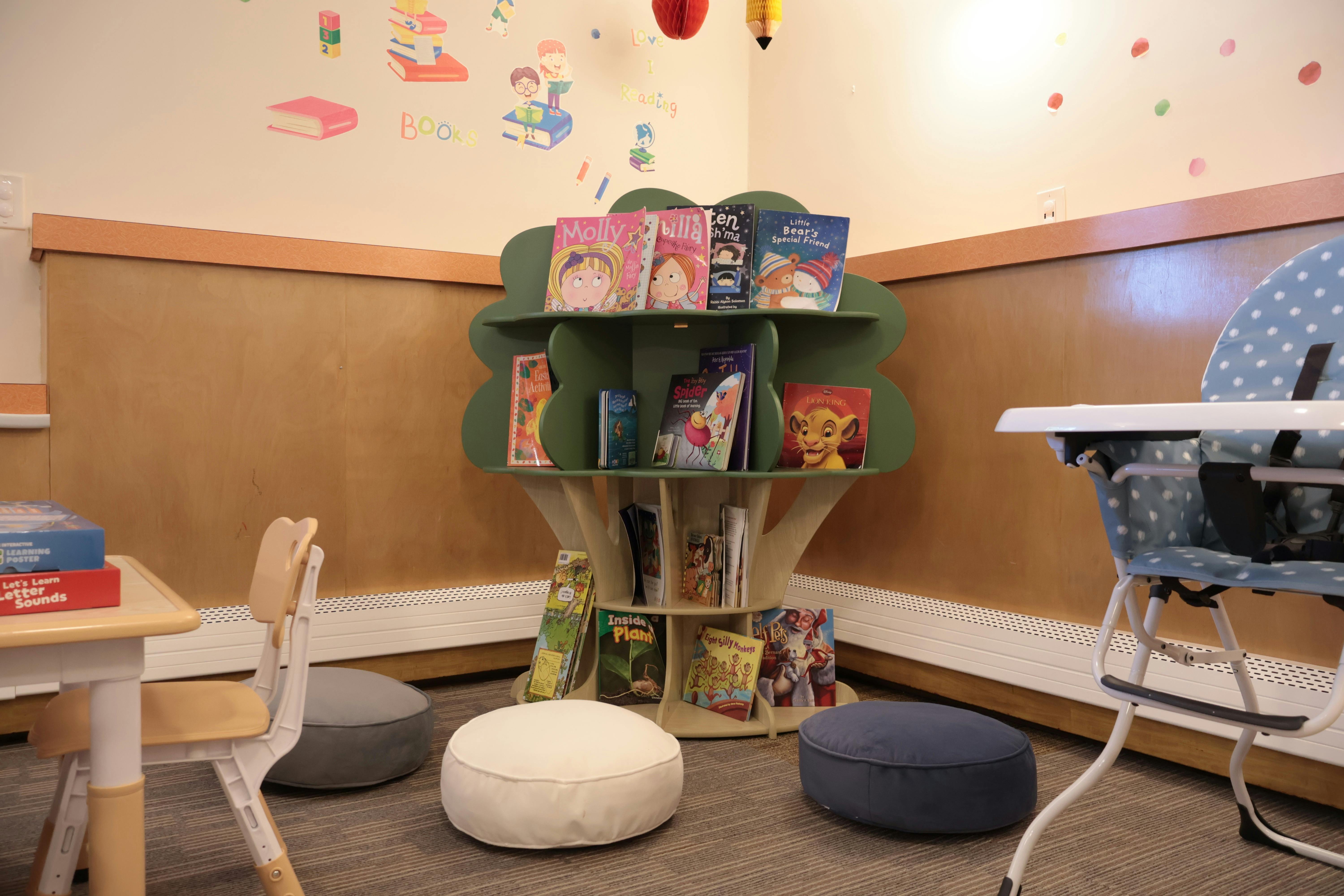 Children's reading nook with a tree-shaped bookshelf and floor cushions