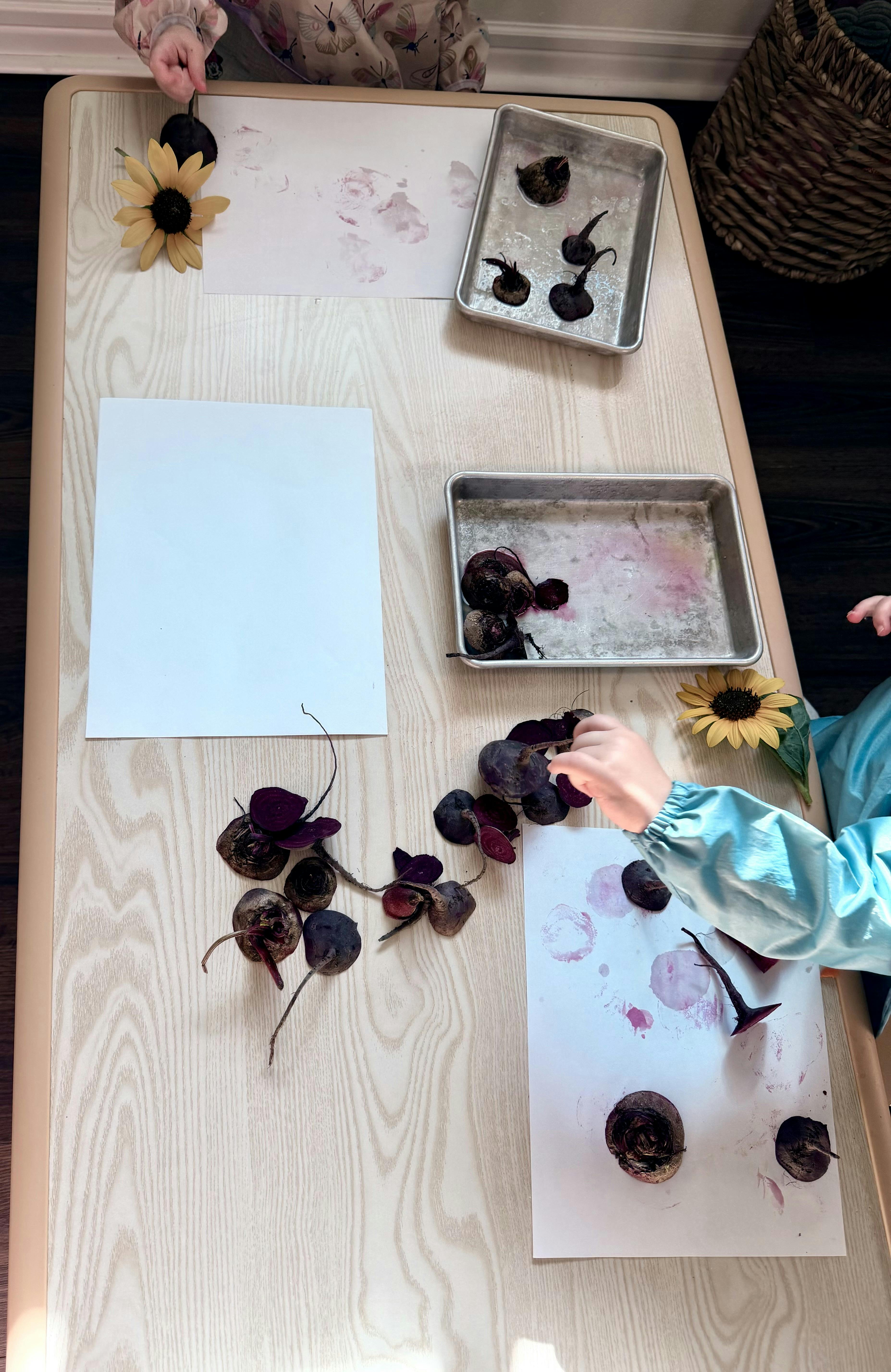 Children stamping with beet halves on paper at a table