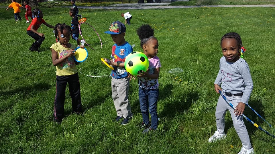 Children playing with toys in a grassy field