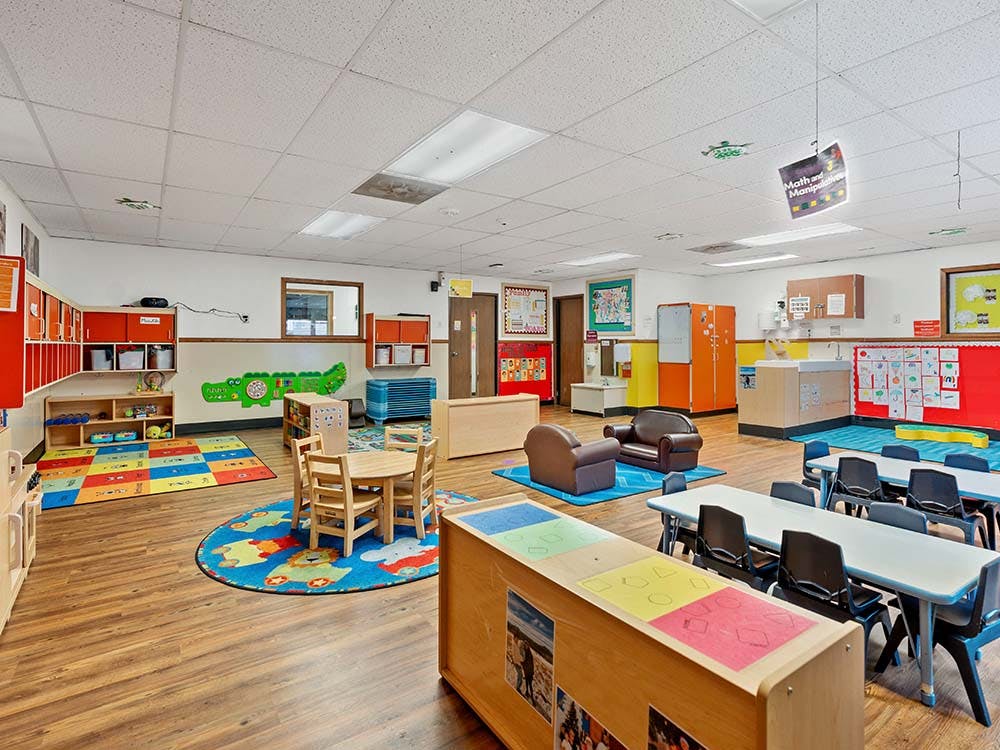 Colorful classroom with various tables, chairs, and play areas