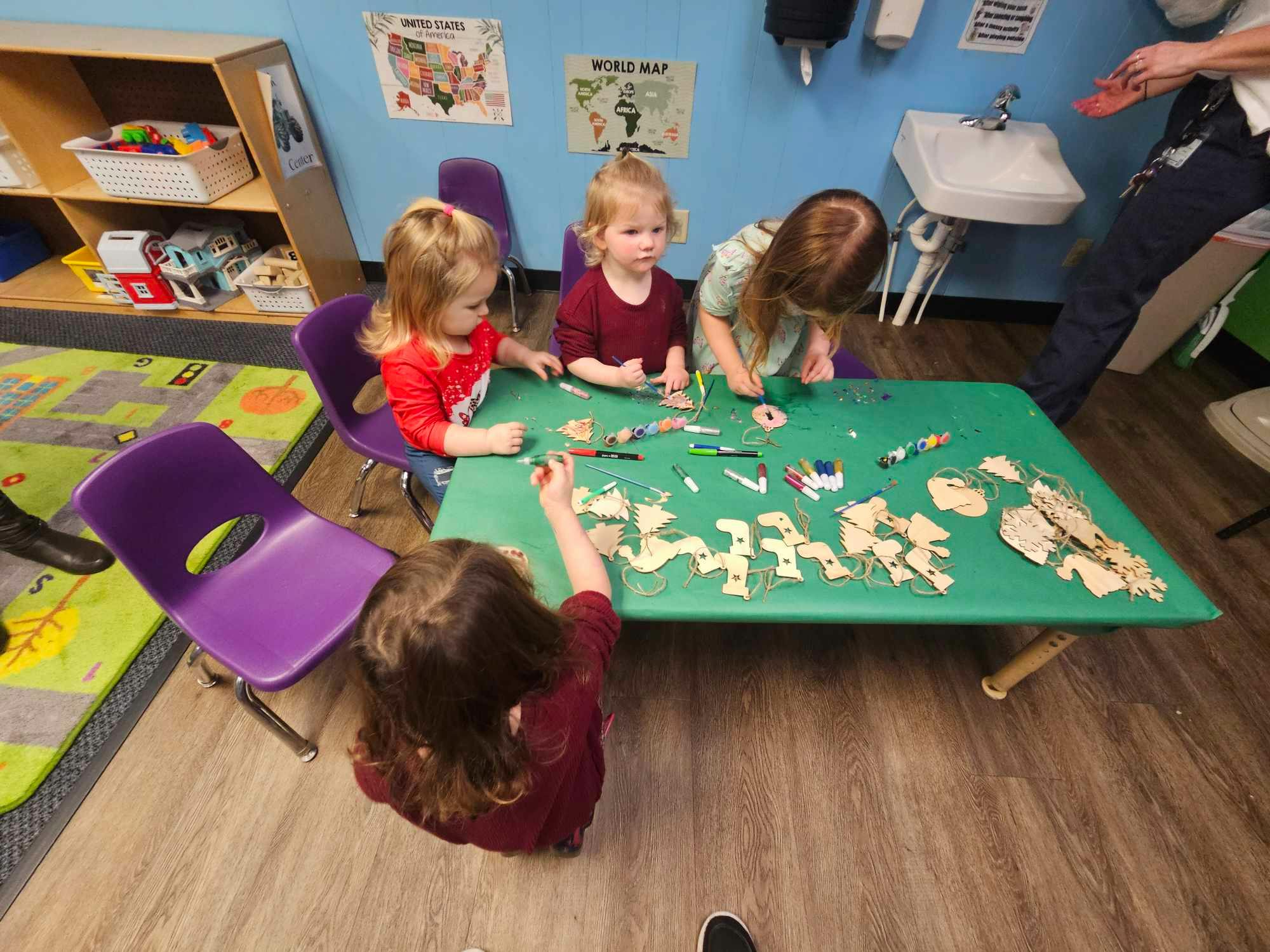 Children at a table playing with small objects in a classroom